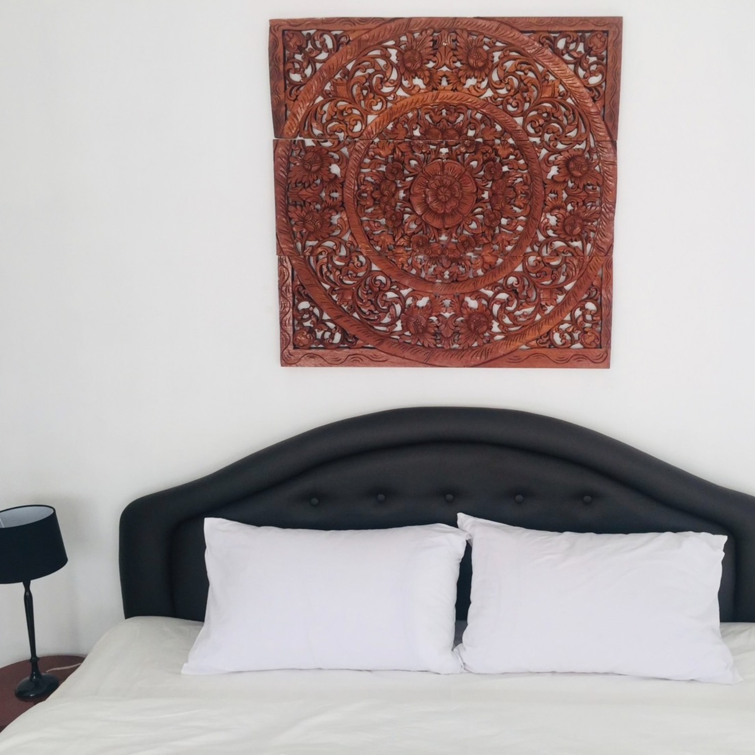 A hand-carved Thai wooden panel above the bed in the Deluxe Double Room at Lyndale Lodge