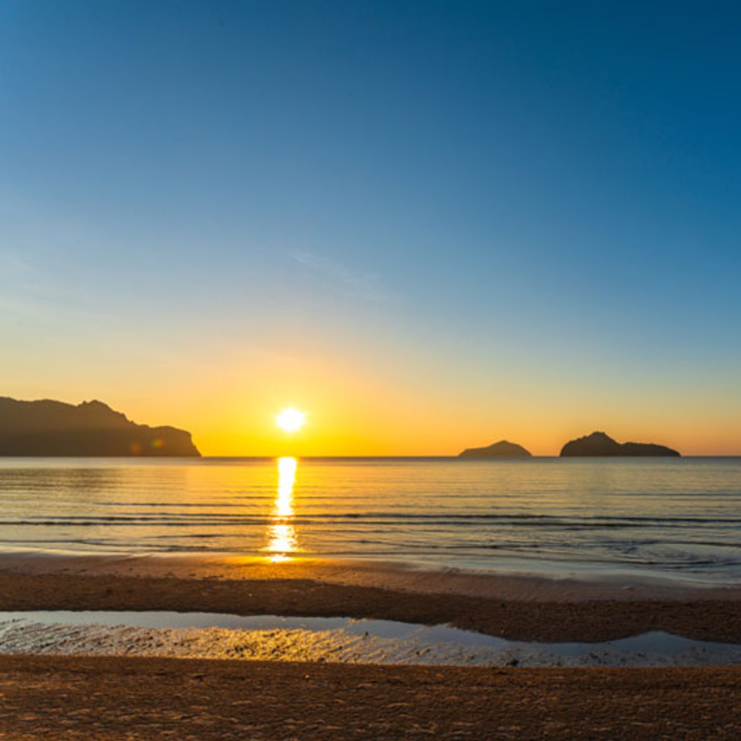 ชายหาดทรายเงียบสงบพร้อมเปลผูกระหว่างต้นไม้ที่อ่าวโลมา ใกล้ Lyndale Lodge