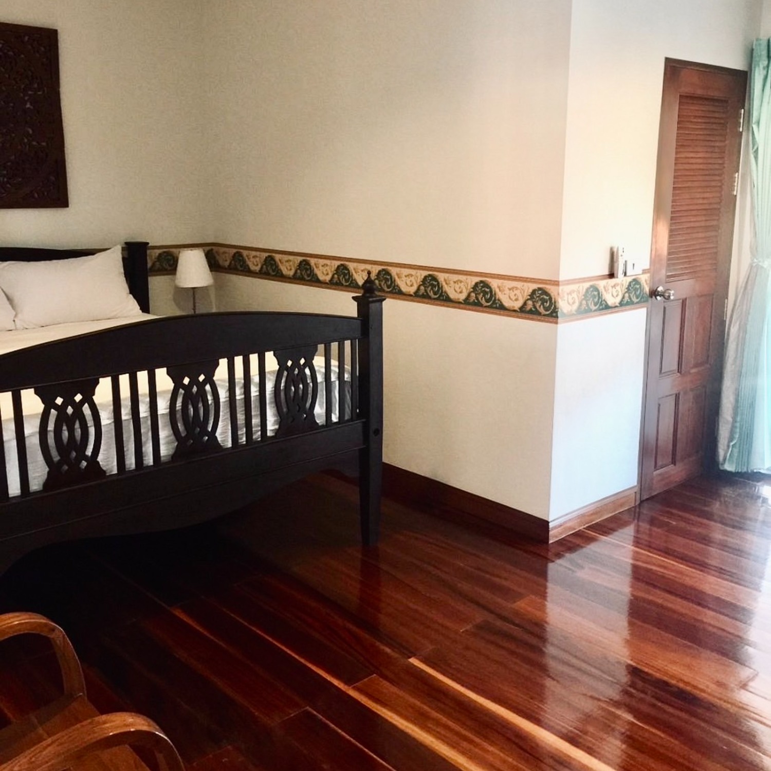 The Premium Double Room at Lyndale Lodge showing the polished hardwood floor and a quiet corner by the door
